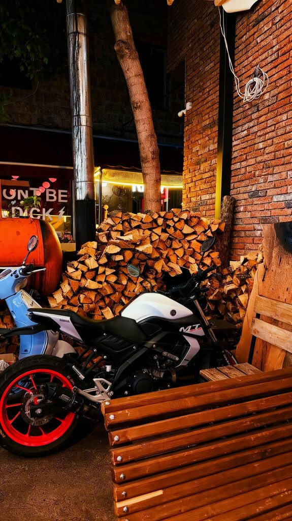 The courtyard at Zeche at night, stacked firewood and neon